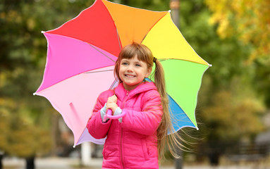Cute girl with colorful umbrella in park