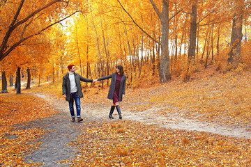 Obraz premium Beautiful young couple walking in autumn park