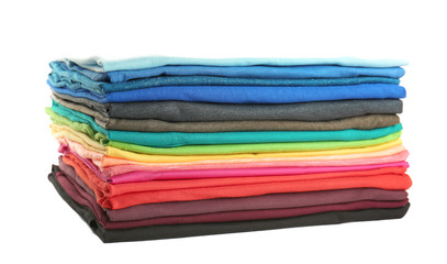 Stack of colorful t-shirts on white background, close up view