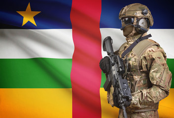 Soldier in helmet holding machine gun with flag on background series - Central African Republic