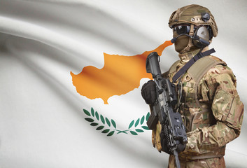 Soldier in helmet holding machine gun with flag on background series - Cyprus