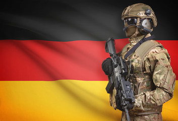 Soldier in helmet holding machine gun with flag on background series - Germany