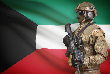 Soldier in helmet holding machine gun with flag on background series - Kuwait