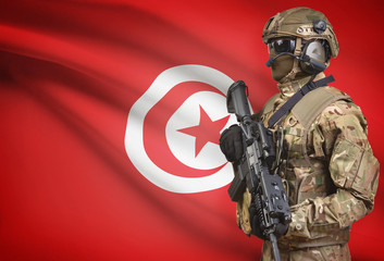 Soldier in helmet holding machine gun with flag on background series - Tunisia