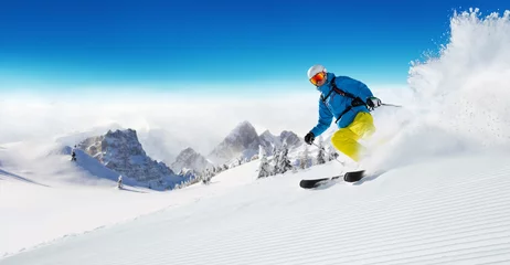 Fotobehang Wintersport Skiër op piste die bergafwaarts loopt