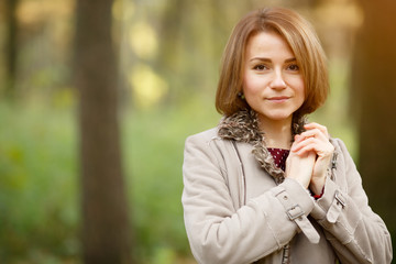 Young woman with brown eyes on fall blurred natural background