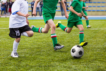 Boys playing football soccer game on sports field