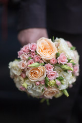 Bridal bouquet in hand of groom