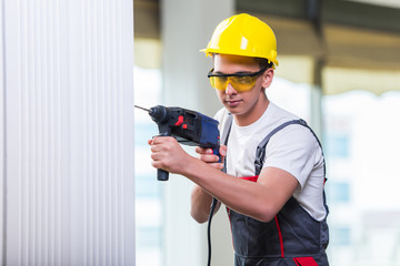 Man drilling the wall with drill perforator