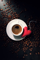 Coffee espresso with coffee beans on a background and red plush