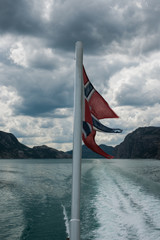 Norwegian flag on a boat sailing in Lysefjorden, Norway.