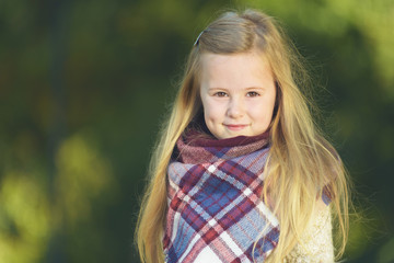 Amazing little girl walking in autumn park.