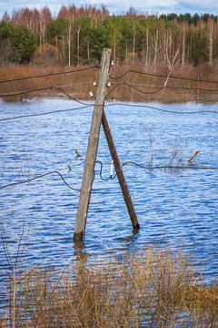 The electricity poles in the water. Flood - the river Mologa.