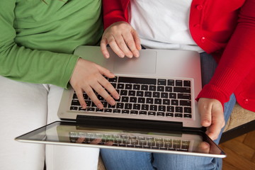 sitting on the sofa and Internet browsing using laptop