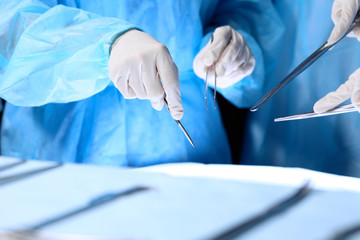 Medical team performing operation. Group of surgeon is working in operating theatre toned in blue
