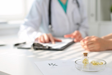 Medicine capsules and pills are lying against the background of a doctor and patient