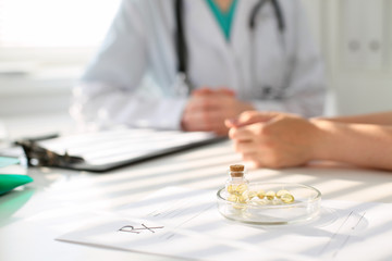 Fototapeta premium Medicine capsules and pills are lying against the background of a doctor and patient