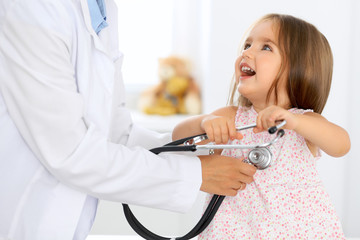 Doctor examining a little girl by stethoscope