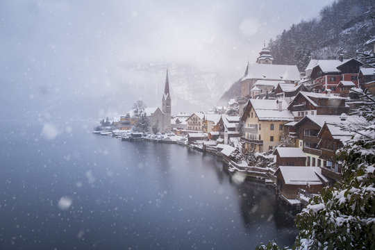 Snow covered town by lake, Hallstatt, Austria