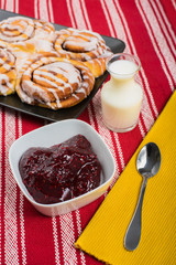 Cinnamon brioche with strawberry jam and milk on rustic background