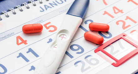 Fototapeta premium Positive pregnancy test with calendar