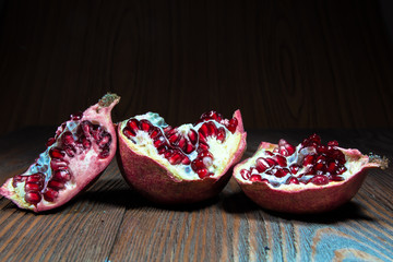 Pomegranates and pomegranate seeds on a dark background