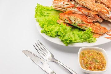Steamed craps serve with Thai hot and spicy seafood sauce and Cutlery Set, isolated on a white background, Top view with copy space
