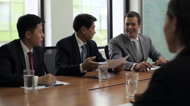 MS Three businessmen meeting with businesswoman in conference room / Beijing, China