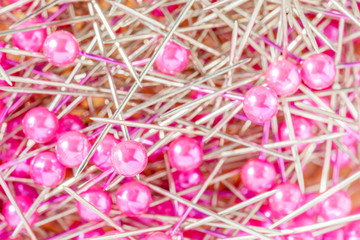 Blurred photo of texture of colorful sewing pins pile and reflec