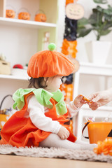 ハロウィンの飾りつけをした部屋の親子