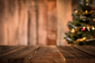 Old wood table top with blur Christmas tree in background