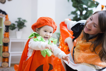 ハロウィンの飾りつけをした部屋の親子