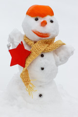 Decorated snowman with scarf and tangerine peel, background of white snow