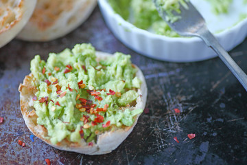 Toasted English muffins with mashed avocado and red pepper flakes