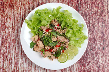 Spicy and sour mixed vegetable salad with canned tuna served .