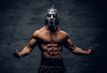 Muscular man in a gladiator silver helmet. - obrazy, fototapety, plakaty