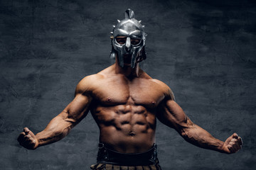 Muscular man in a gladiator silver helmet. - obrazy, fototapety, plakaty