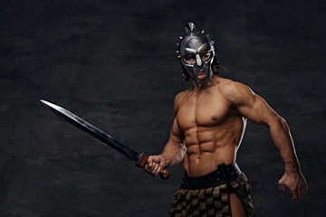 Fototapeta premium A man in a silver gladiator helmet holds an iron sword.