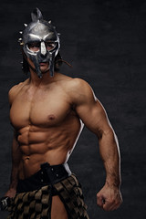 Shirtless athletic male in silver gladiator helmet.