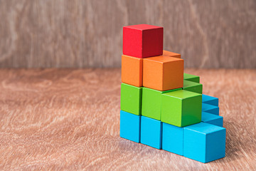 Obraz premium stack of colorful wood cube building blocks on wood background