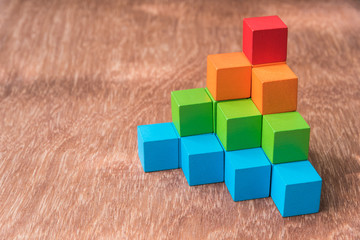 Obraz premium stack of colorful wood cube building blocks on wood background