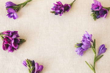 Purple flowers on linen toning copy space background