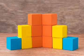Obraz premium stack of colorful wood cube building blocks on wood background