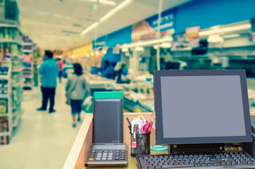 Cashier operating at the cash desk over the Abstract blurred pho