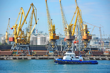 Fototapeta premium Tugboat and port cargo crane