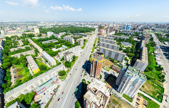 Aerial city view with crossroads and roads, houses, buildings, parks and parking lots, bridges. Urban landscape. Copter shot. Panoramic image.