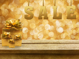 SALE and gift boxes on wooden table with gold bokeh background