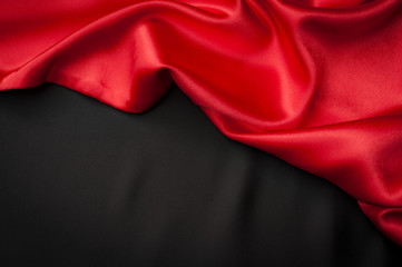 Valentine’s day concept with two silk layers of different colors one red and the other one black with copy space