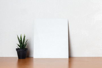Blank white paper with little tree on a wooden desk