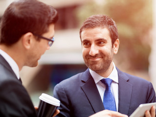 Two businessmen talking outdoors